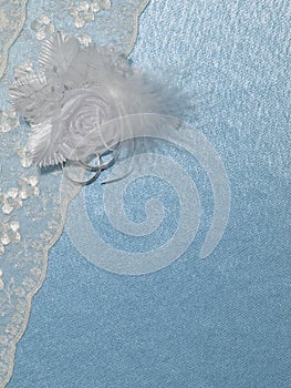 Background blue silk with weddings rings and lace