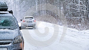 Background, blur, out of focus, sideways. A car during a snowstorm on the road with its headlights on. Winter, snow