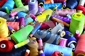 Background of bobbins with multicolored threads for sewing. Needlework, sewing and tailoring concept.