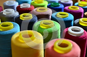 Background of bobbins with multicolored threads for sewing. Needlework, sewing and tailoring concept.