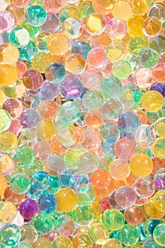 Background of bright multi color transparent gel balls on a sunny day and concept of multitude.