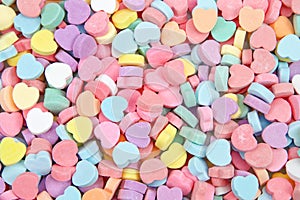 Background of brightly colored candy hearts for Valentine`s Day photo