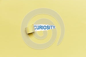 Background of a broken yellow cardboard showing the word CURIOSITY