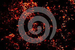 background of burning and glowing hot coals. smoldering embers of fire. flicker of burning coals at night.
