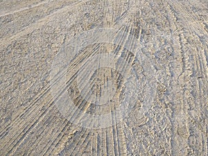 Background of car wheel tracks in the sand. Tire marks in sand close up