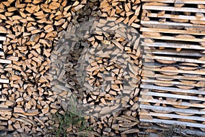 Background on chopped firewood stacked in woodpile .