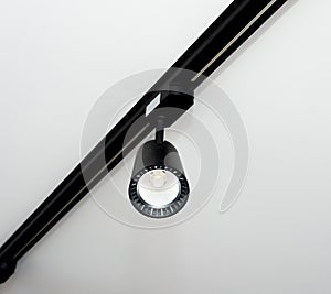 Background close-up Led track lamp on the ceiling in the interior. Interior spotlight in black color. Modern track lamp with many