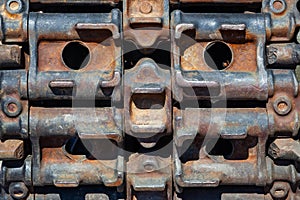 Background Close-up on a rusty old caterpillar of green tank worn on wheels standing on the road. Military equipment for the