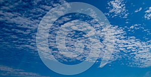 Background with clouds on blue sky. Sky view. Beautiful sunny sky. Clouds on blue sky. Sun shining through the puffy clouds.