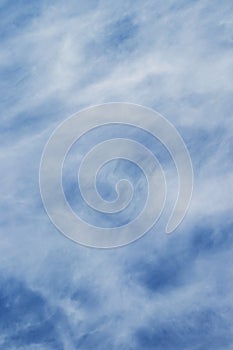 Background with clouds of uncertain shape in light blue sky, vertical_