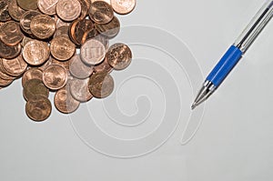 Background with coins and pen on top of a sheet of paper