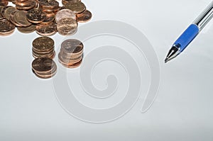 Background with coins and pen on top of a sheet of paper