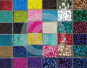 Background of colorful bright beads in boxes, set for needlework