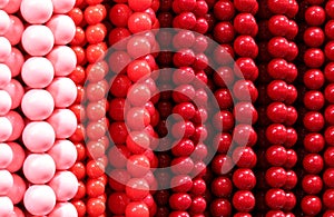 background of colorful necklaces made of red and pink pearls in the shop