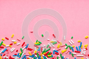 Background of colorful sprinkles over pink, festive invitation for Valentines day, birthday, holiday and party time, copy