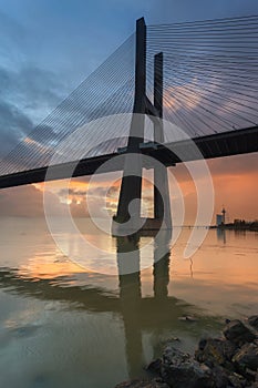 Background with colourful sunrise on the Lisbon bridge. The Vasco da Gama Bridge is a landmark, and one of the longest bridges in