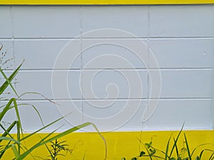 Background composition with yellow horizontal stripes displayed on a white painted plaster wall