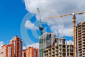 Background of the construction site. Cranes and new multi-storey buildings