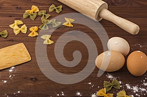 Background cooking. Eggs, flour, rolling pin, tolkushka on a wooden table.