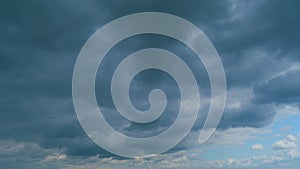 Background of dark dramatic sky with stormy clouds. Moving white puffy clouds on blue sky. Time lapse.