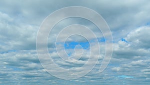 Background of dark dramatic sky with stormy clouds. Moving white puffy clouds on blue sky. Time lapse.