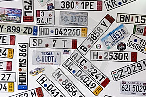 Background of different car license plates from different countries on a white wall