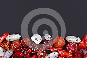 Background with different roleplaying RPG dice at bottom of dark black background with blank copy space