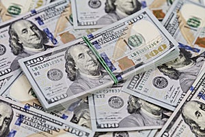 Background of dollar bills and a bundle of dollars on top