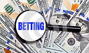 Background with dollar bills under a magnifying glass with the text BETTING. Financial concept