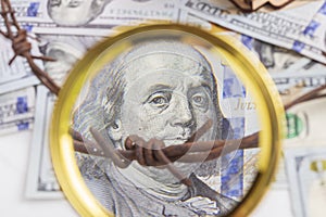 the background of dollars on it is barbed wire. close-up