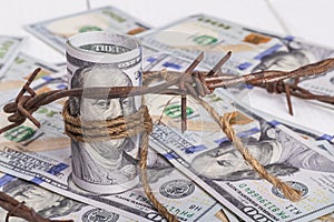 the background of dollars on it is barbed wire. close-up