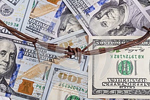 the background of dollars on it is barbed wire. close-up