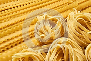 Background of dried pasta, tagliatelle and mafaldini