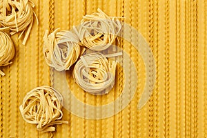 Background of dried pasta, tagliatelle and mafaldini