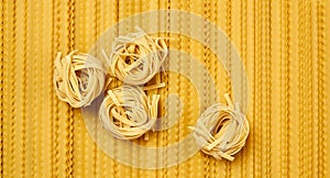 Background of dried pasta, tagliatelle and mafaldini