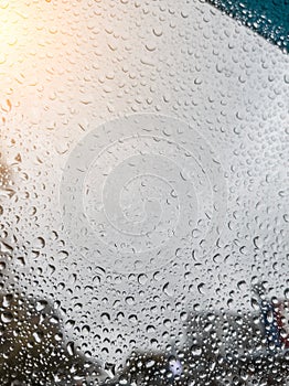 Background from drops of water and rain on a car glass window on a cloudy autumn day. Calmness, freshness, weather