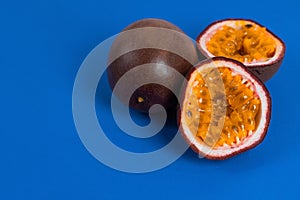 Background of exotic Asian fruits. Sliced passion fruit. Fresh passion fruit on a blue background. A place to copy.