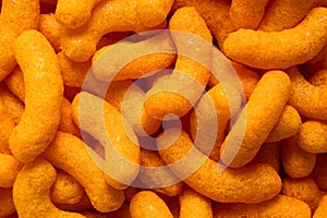 Background of extruded cheese puffs. Top view