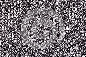 Background from a fabric texture. Wool knitted fabric with cable seamless pattern of white black color. Textile closeup.Concept of