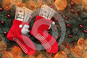 Background of fir branches. Santa`s red stockings with money. Christmas card. Top view. Effect of light blips