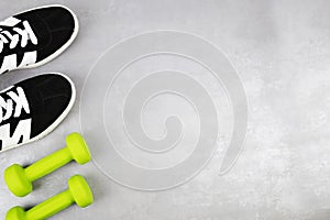 The background of the fitness concept with sneakers, dumbbells. Top view with a place for your text.