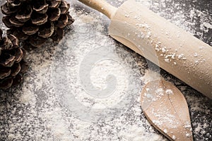 Background of flour and baking utensils with pine cones