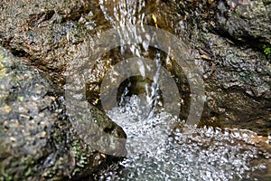 Background flowing water falling between the rocks in the river