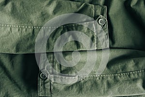Background of folding sleeves of green jacket and buttons with seam line. Clothing detail. Top view. Copy, empty space for text