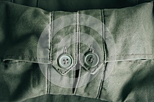 Background of folding sleeves of green jacket and buttons with seam line. Clothing detail. Top view. Copy, empty space for text