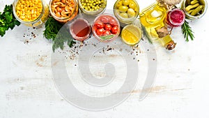 Background of food stocks in glass jars. Pickled vegetables and mushrooms.