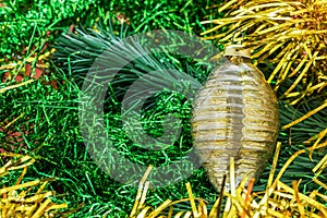 Background in the form of Christmas tree decorations - golden garland, branches of spruce, green and golden rain