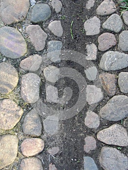 Background. fragment. texture. the old road is paved with wild stone, cobblestones. landscape design, natural style.