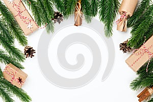 background frame of Christmas tree branches with cones, holiday gifts, tied with jute rope cinnamon, isolated on white