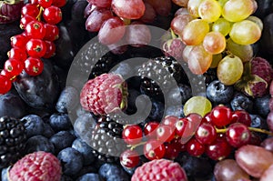 Background of fresh fruits and berries. Ripe blackberries, blueberries, plums and raspberries. Mix berries and fruits. Top view. B